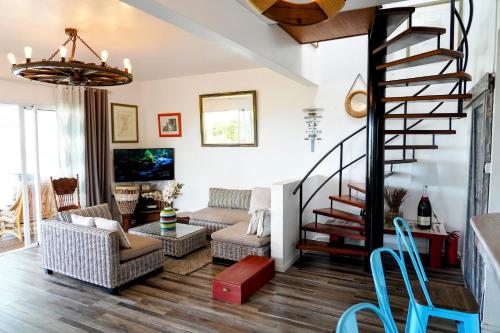 uma sala de estar com uma escada em espiral e um sofá em Villa Kai em Trou dʼEau Douce