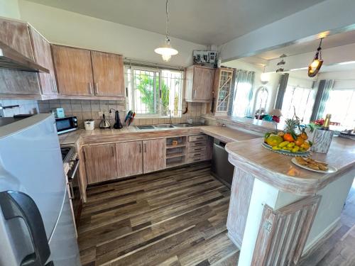 una cocina con armarios de madera y un bol de fruta en la barra en Villa Kai, en Trou d'Eau Douce