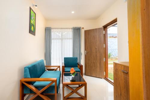 a room with two chairs and a table and a window at Le Serene Munnar Luxury Resorts & Spa in Ūdumbanshola