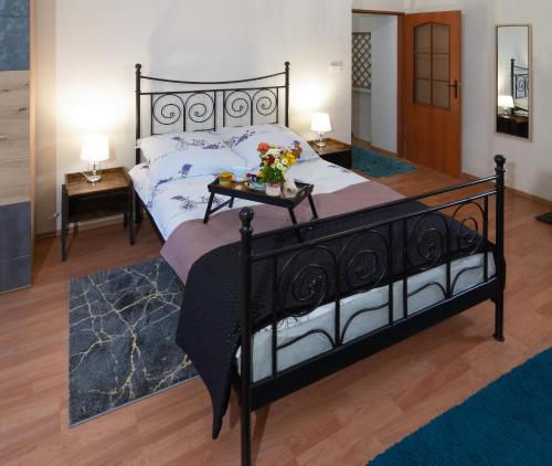 a bedroom with a black bed with a tray of flowers on it at Czar Prowansji - Comfy & Quiet near Rynek&Train Station in Krakow