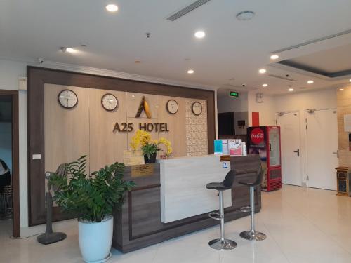 vestíbulo del hotel con mostrador y 2 taburetes en A25 Hotel - Hoàng Đạo Thuý, en Hanói