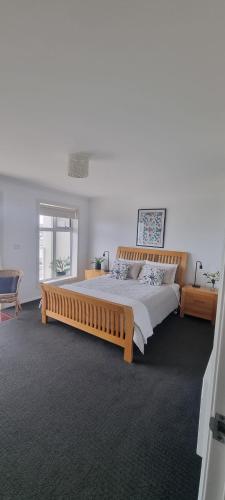 a bedroom with a large bed with a wooden frame at Church Street Villas in Stanley