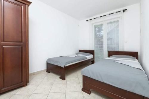 two beds in a room with a window at Apartments Ljubica Tivat in Tivat