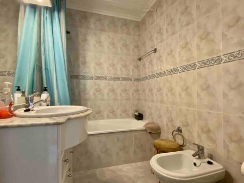 een badkamer met een wastafel, een bad en een toilet bij Jardins Da Rocha by CORAL in Portimão
