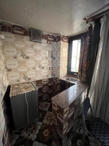a dirty kitchen with a sink and a refrigerator at Nubian Dreams Guest House in Aswan