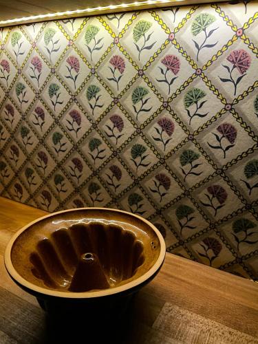 a metal bowl in front of a tiled wall at La Chambre des Trois Églises in Riquewihr