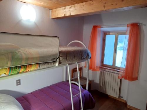 a bedroom with a bunk bed and a window at Terratetto 90 mtq 10 posti letto in SantʼAnna Pelago