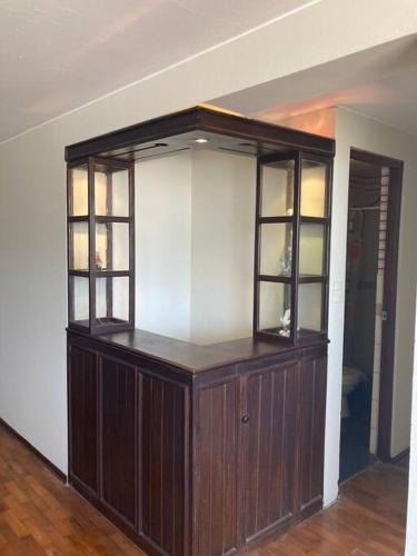 Apartamento en Pueblo Libre في ليما: خزانة خشبية كبيرة مع نوافذ زجاجية في الغرفة