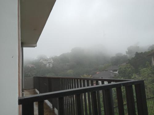 a balcony with a view of a misty mountain at Windy Hanthana in Kandy