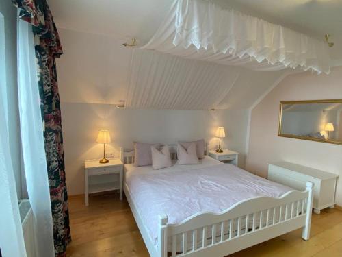 1 dormitorio con 1 cama blanca con 2 mesas y 2 lámparas en Appartement Resch en Mariapfarr