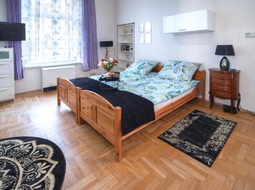 a bedroom with a bed and a wooden floor at Cozy Apartament Rachel-Near Rynek and train station in Krakow