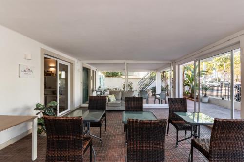 a living room with tables and chairs and a couch at Le Torrette Rooms and Apartments in Avola