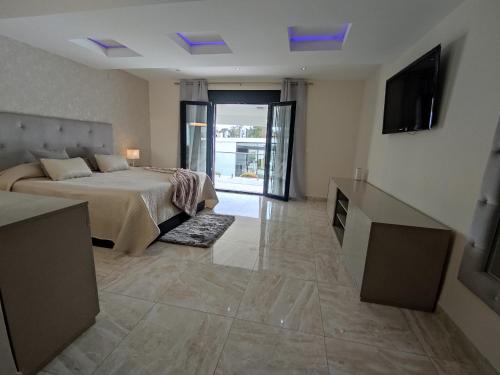 um quarto com uma cama e uma televisão na parede em Villa lujo Costa del Sol con piscina-jacuzzi em Torremolinos