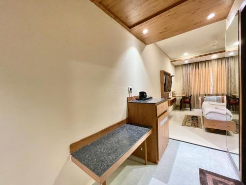 um quarto com uma secretária e uma televisão num quarto em Hotel Rockbay-near sea beach & temple em Puri