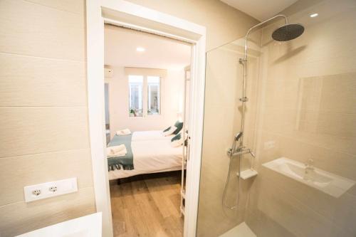 a bathroom with a shower and a bedroom with a bed at Capricho de la Judería Suites in Córdoba