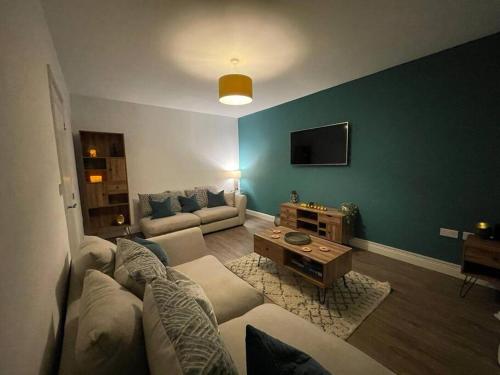 a living room with a couch and a tv at Crib Coed in Old Colwyn