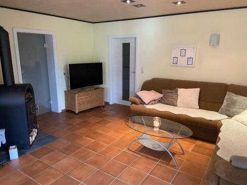 a living room with a couch and a tv at Ferienwohnung Sattler in Mistelgau