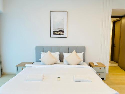- une chambre avec un grand lit blanc et des oreillers blancs dans l'établissement EATON RESIDENCE AT KLCC, à Kuala Lumpur
