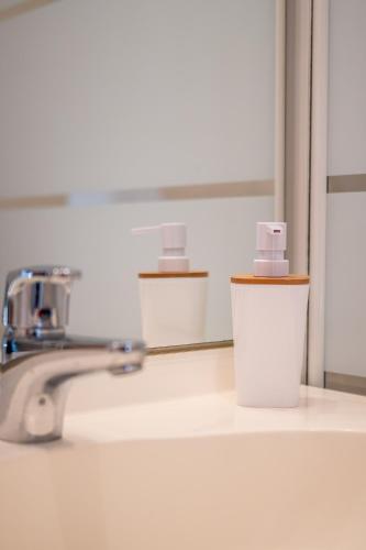 un lavabo de salle de bain avec un robinet et un miroir dans l'établissement Le 24-GregIMMO-Appart'Hôtel, à Belfort