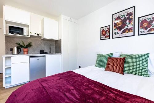une chambre avec un grand lit et une cuisine dans l'établissement Studio douillet /Centre ville, à Strasbourg