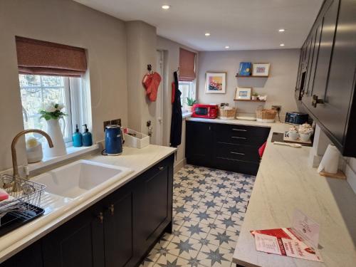 a kitchen with a sink and a counter top at Coral Cottage Amble in Amble