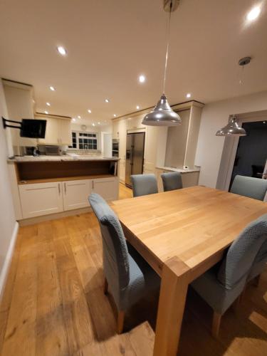 uma cozinha e sala de jantar com uma mesa de madeira e cadeiras em Polkerris Way 1 em Fleet