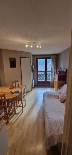 Cette chambre comprend une table, un lit et un bureau. dans l'établissement Appartement 4/6 le lioran, à Laveissière