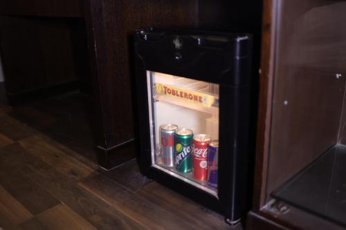 an open refrigerator with cans of soda and cocacola at Hotel Grand Godwin - Free Airport Pick-Up in New Delhi