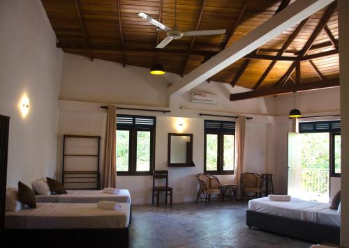 a living room with two beds and a table at The Dom hotel & restaurant in Ahangama