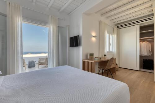 a white bedroom with a view of the ocean at Villa HADI, ideal for large groups and families in Kalo Livadi