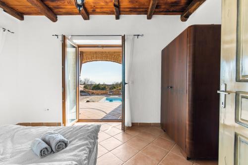 a bedroom with a bed and a door to a pool at Vila Majda in Čabrunići