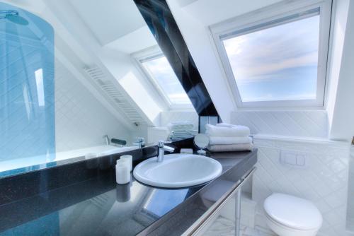 ein Bad mit einem Waschbecken, einem WC und einem Fenster in der Unterkunft Windeby 3D in Wenningstedt-Braderup
