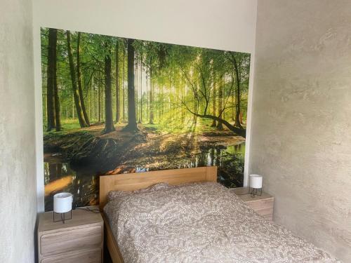 a bedroom with a forest mural on the wall at Stawiska nad tanwia in Jędrzejówka