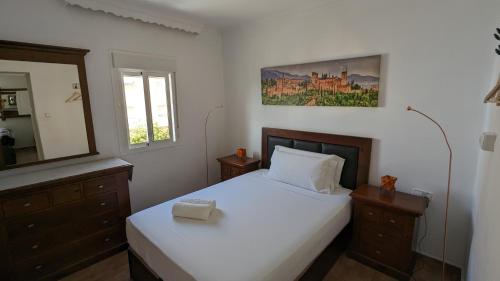 1 dormitorio con cama blanca y espejo en Apartamento Jerez Centro, en Jerez de la Frontera