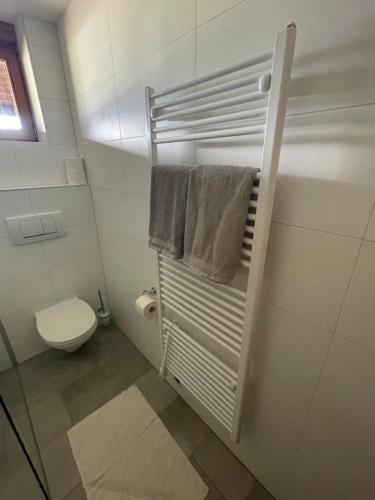 a bathroom with a toilet and a towel rack at Landhaus Peer in Innsbruck