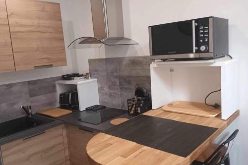 - une cuisine avec un comptoir et un four micro-ondes dans l'établissement Appartement de l'EST N°2, à Montluçon