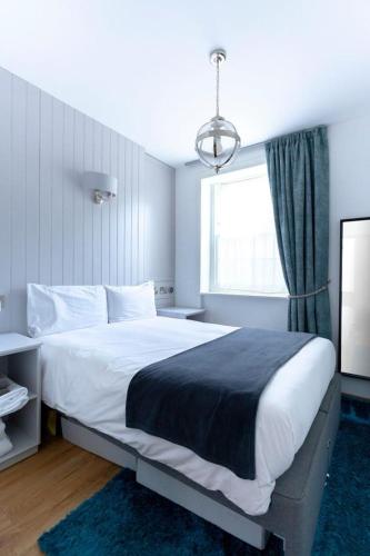 a bedroom with a large bed and a window at Ground floor apartment at Number 8: king bed, en-suite, lounge, kitchenette in Kent