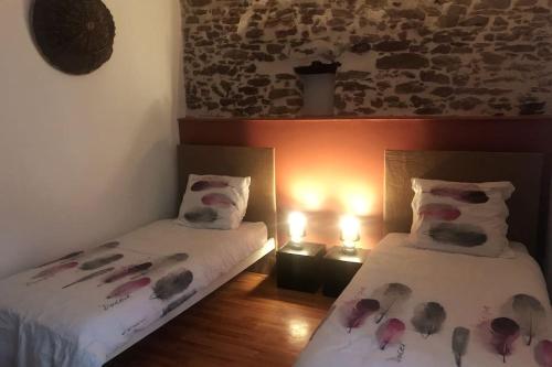 1 dormitorio con 2 camas con flores en las sábanas en Le Refuge d'Aglaé en Legé