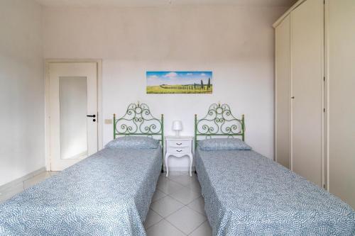 2 Betten in einem Zimmer mit blauen Tagesdecken in der Unterkunft Comfy Flat Steps Away from Siena Station! in Siena