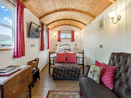 a living room with a couch and a bed at Shepherds Hut - Uk45529 in Buildwas