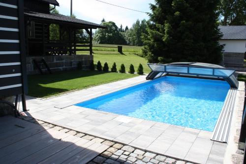 a swimming pool in a yard with a house at Penzion Semerink in Janov nad Nisou