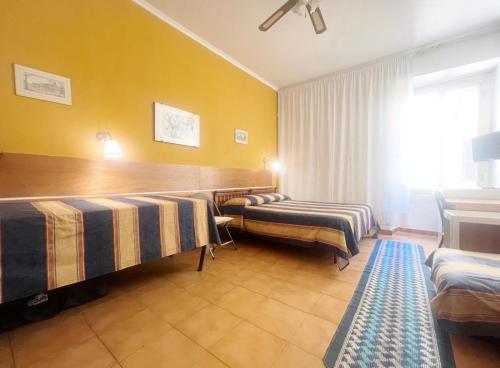 ローマにあるB&B Vaticanroomsのベッド2台と窓が備わるホテルルームです。