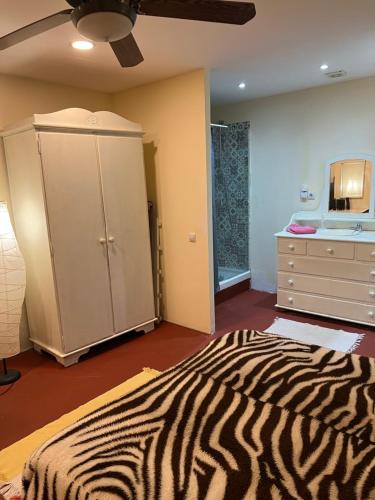 een bed met zebraprint in een kamer met een dressoir bij Apartamento abierto con patio in Matadepera