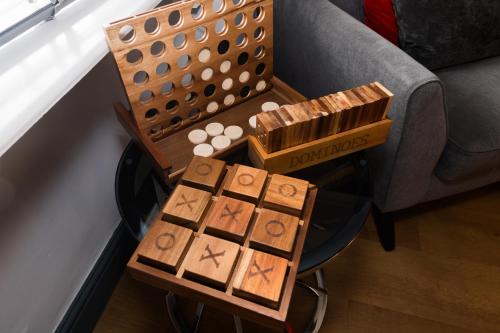 a wooden board game on a stool next to a couch at Crown and Cushion Appleby in Appleby