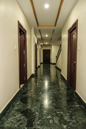 un couloir vide d'un bâtiment avec des sols et des portes en marbre dans l'établissement THE LUSHAI INN, à Aizawl