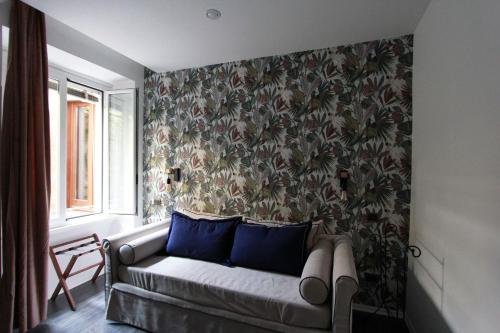 uma sala de estar com um sofá contra uma parede com um papel de parede em Avignonesi Flat em Roma
