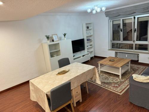 a living room with a table and a tv at Piso nuevo Centro Doctor Casal in Oviedo