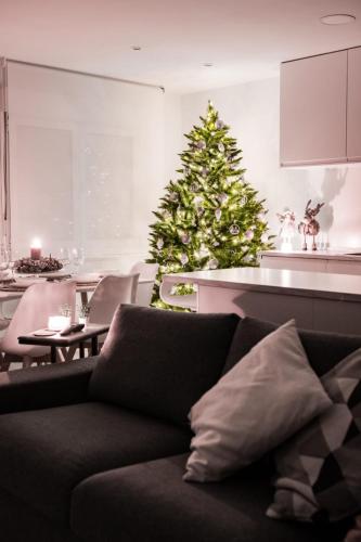 a christmas tree in a living room with a couch at Lujoso apartamento entre 2 playas con garaje, wifi in Gijón