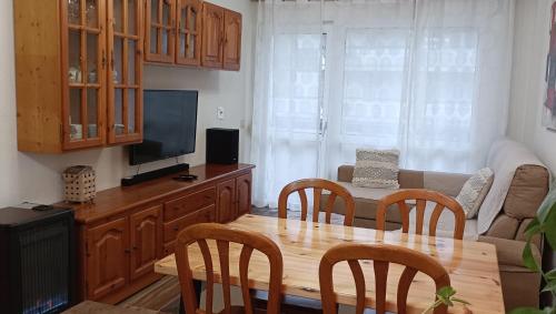 a living room with a wooden table and a television at Apartamento a 30 metros de la playa in San Vicente de la Barquera