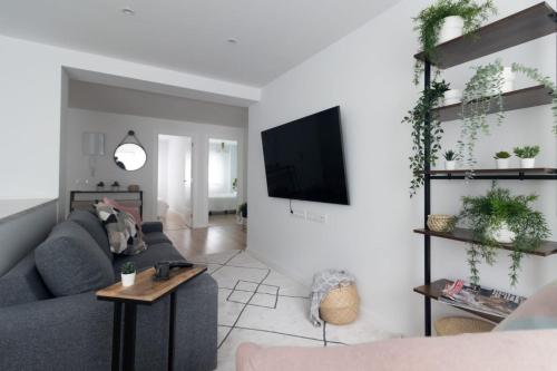 a living room with a couch and a tv at Lujoso apartamento entre 2 playas con garaje, wifi in Gijón